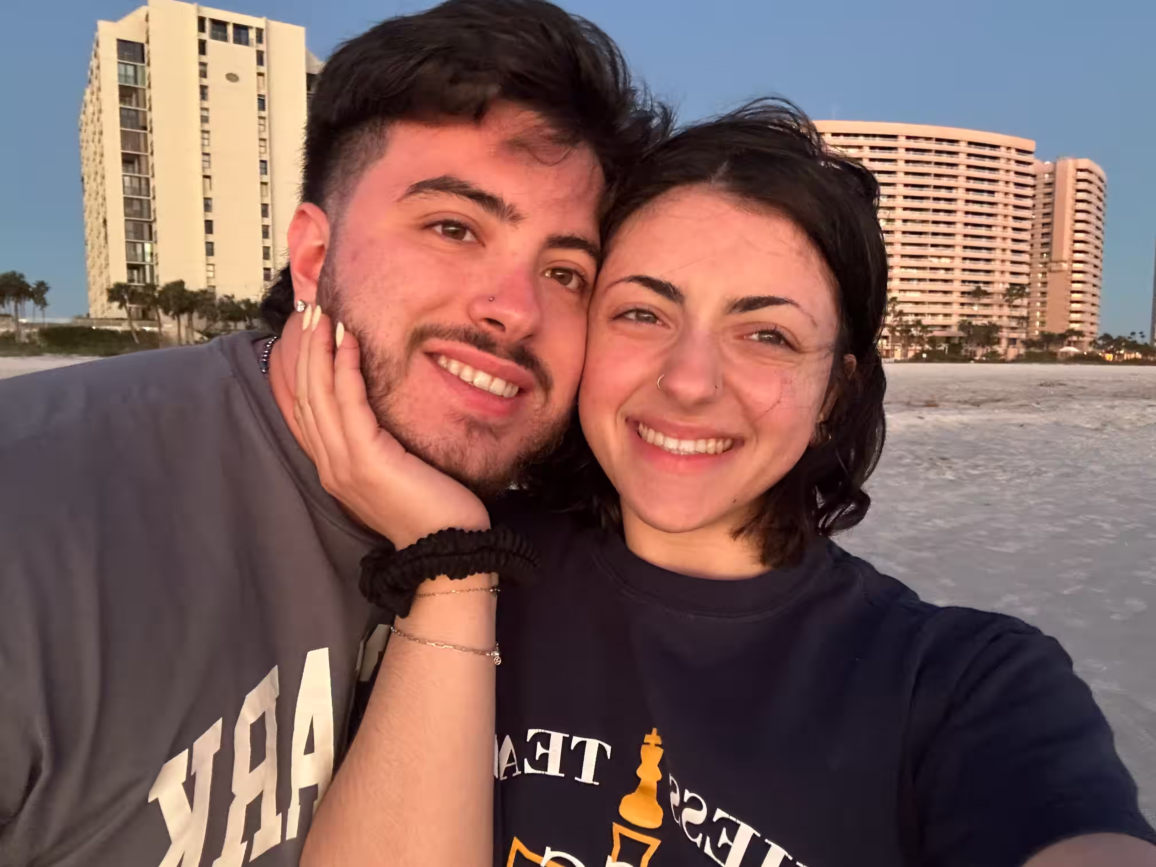 Ben Anthony Minervino with his girlfriend smiling on the beach at sunset.